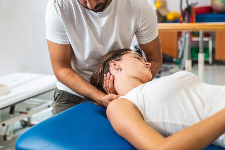 A chiropractor gently performing a spinal adjustment on an adult in a bright, comfortable clinic room.